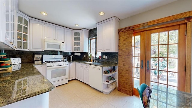 kitchen featuring white cabinetry, dark stone countertops, white appliances, and french doors