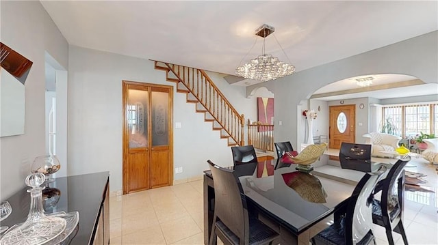 dining area with light tile patterned floors and an inviting chandelier