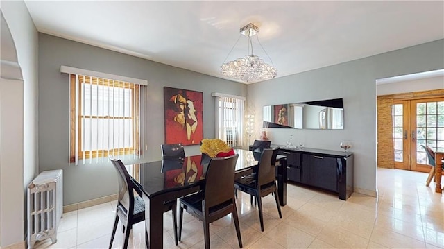 dining area featuring radiator heating unit, light tile patterned floors, french doors, and a notable chandelier