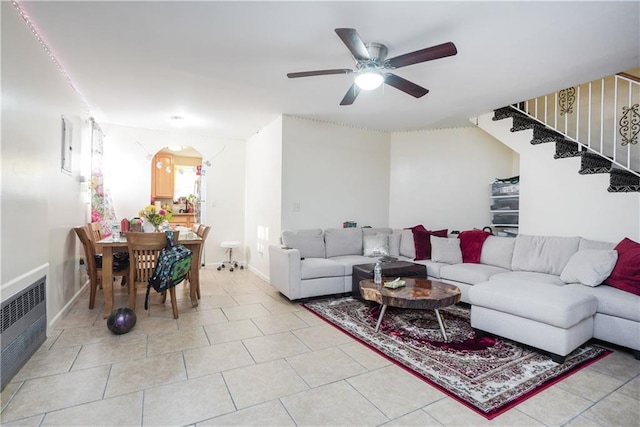 living room featuring light tile patterned flooring, radiator, and ceiling fan