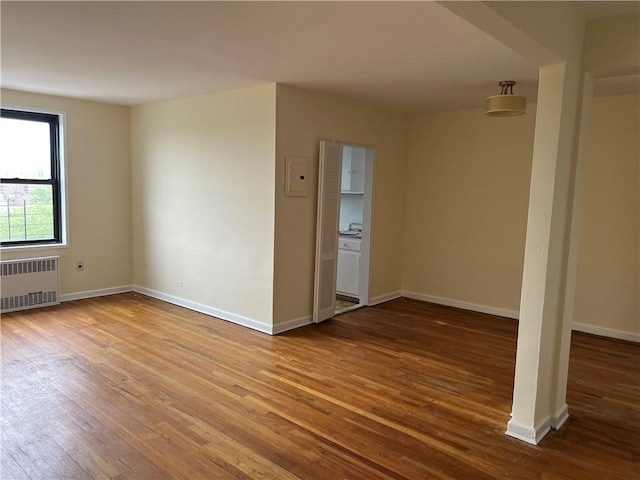 empty room featuring hardwood / wood-style flooring and radiator