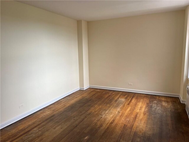 empty room with dark hardwood / wood-style floors