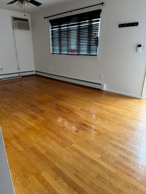 empty room featuring light hardwood / wood-style flooring, an AC wall unit, and ceiling fan