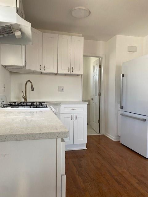 unfurnished room with dark colored carpet, ceiling fan, and a baseboard radiator