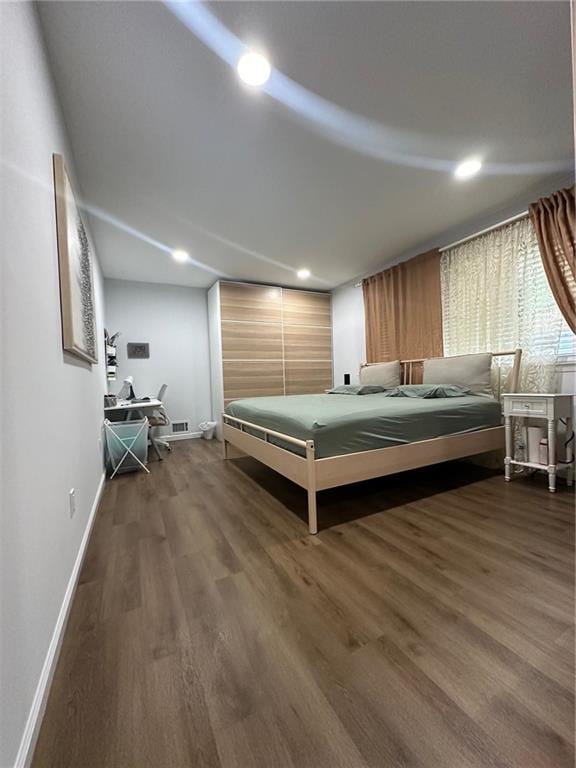 bedroom with recessed lighting, baseboards, and dark wood finished floors