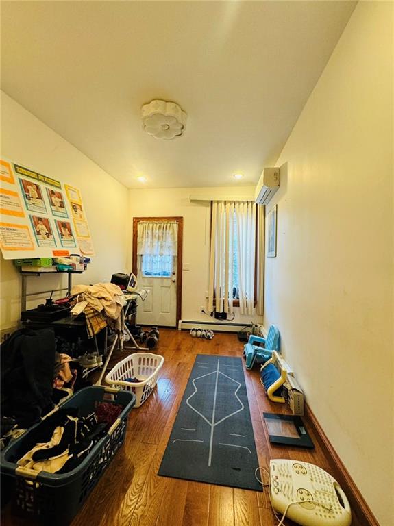 workout room featuring dark hardwood / wood-style floors and a wall mounted air conditioner