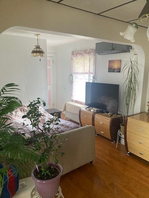 living room featuring an AC wall unit and dark hardwood / wood-style flooring