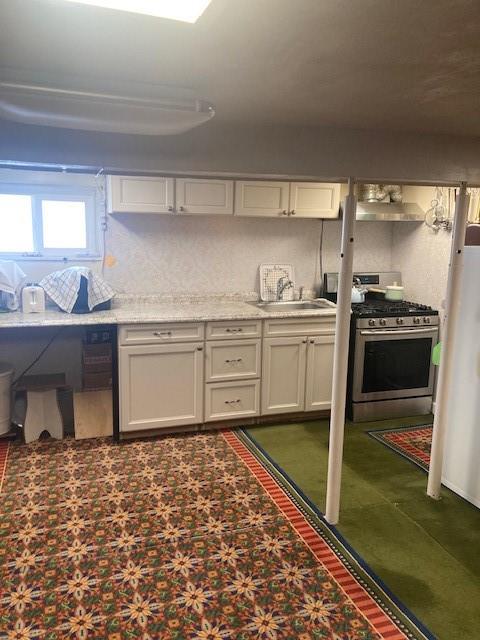 kitchen featuring sink, stainless steel range with gas cooktop, and white cabinets