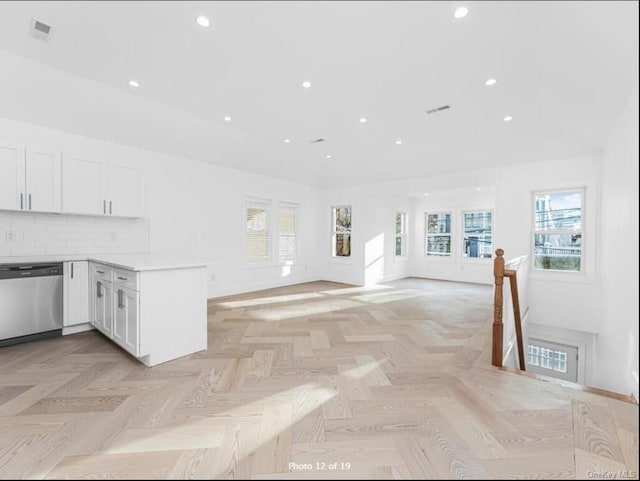 kitchen featuring white cabinets, open floor plan, light countertops, dishwasher, and tasteful backsplash