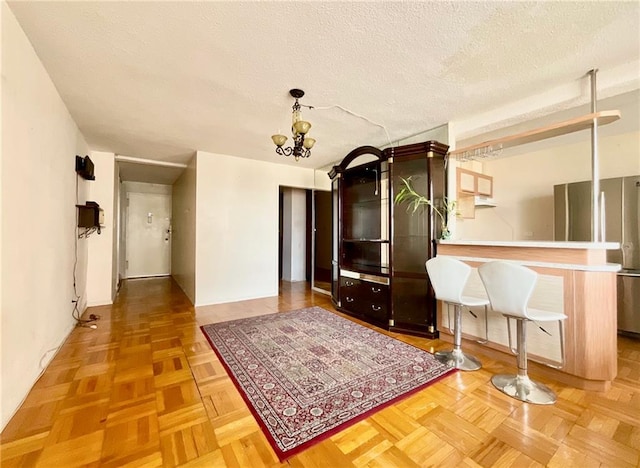 interior space with parquet flooring, a chandelier, and a textured ceiling