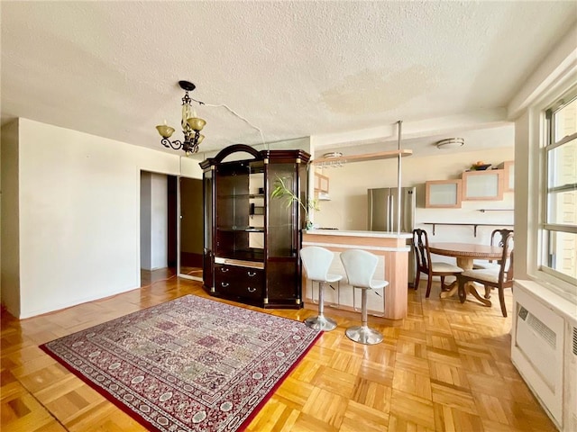 interior space with parquet flooring, a notable chandelier, and a textured ceiling