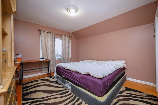 bedroom with light hardwood / wood-style flooring and lofted ceiling