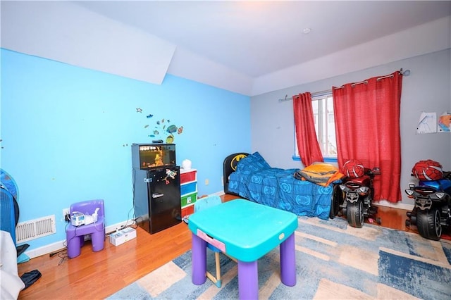 bedroom featuring hardwood / wood-style flooring and lofted ceiling