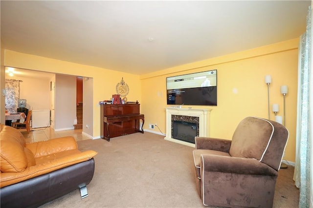 carpeted living room with a high end fireplace