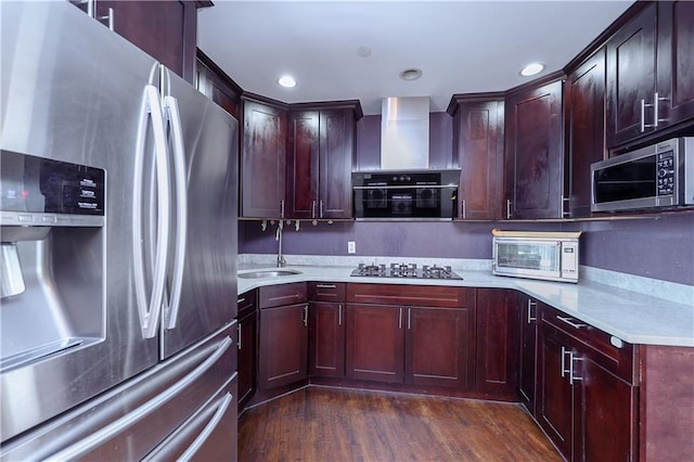 kitchen with sink, dark wood-type flooring, wall chimney range hood, and appliances with stainless steel finishes