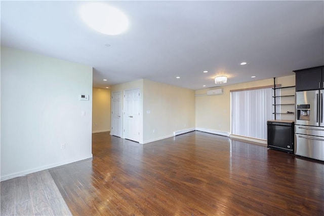 unfurnished living room featuring dark hardwood / wood-style flooring, an AC wall unit, and baseboard heating