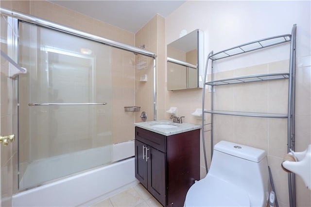 full bathroom with tile patterned floors, vanity, tile walls, enclosed tub / shower combo, and toilet