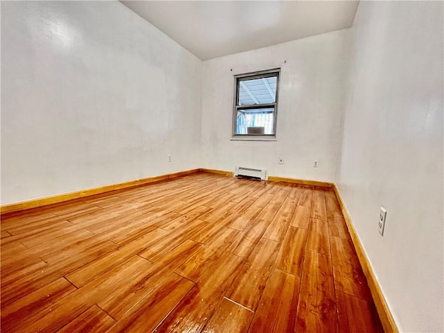 empty room featuring light hardwood / wood-style flooring and a baseboard heating unit