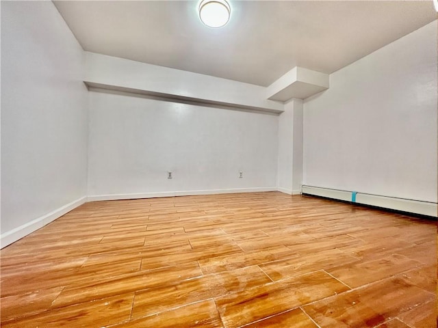 unfurnished room featuring light hardwood / wood-style flooring and baseboard heating