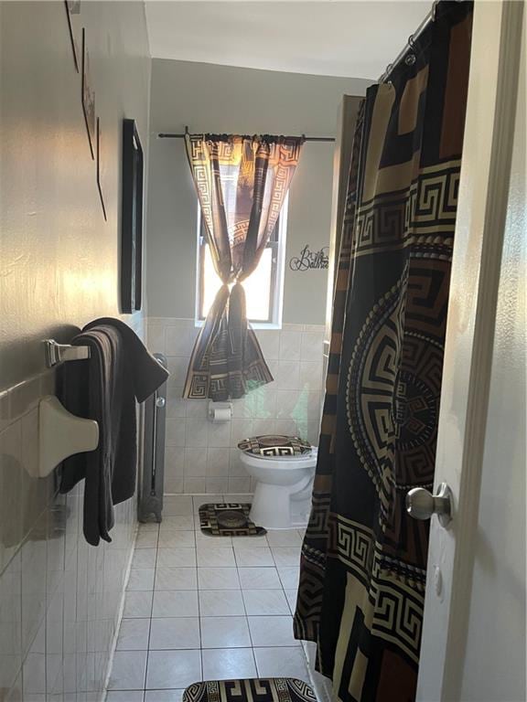 bathroom with tile walls, tile patterned floors, and toilet