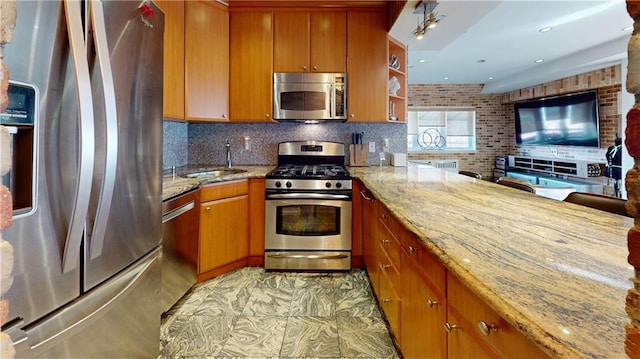 kitchen with tasteful backsplash, sink, light stone countertops, and appliances with stainless steel finishes