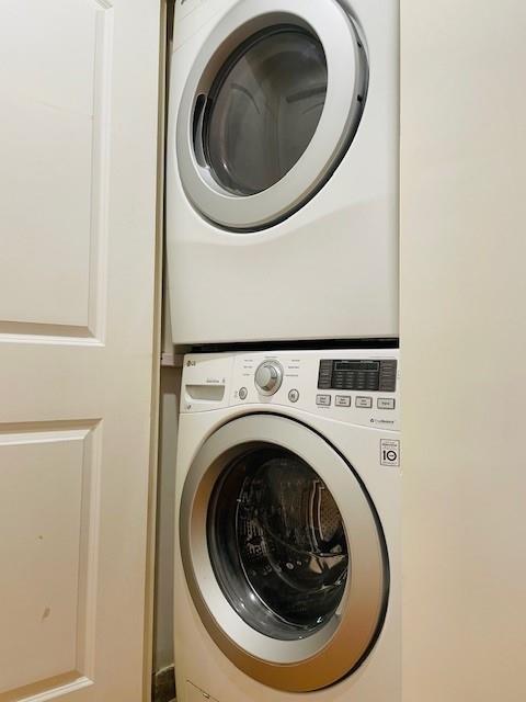 washroom featuring stacked washer and clothes dryer