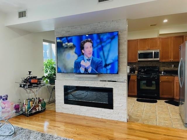 living area with recessed lighting, light tile patterned floors, a fireplace, and visible vents