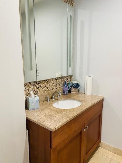 bathroom with tasteful backsplash, vanity, and tile patterned flooring