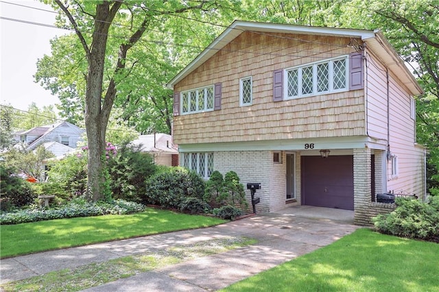 view of front of property featuring a garage, brick siding, driveway, and a front lawn