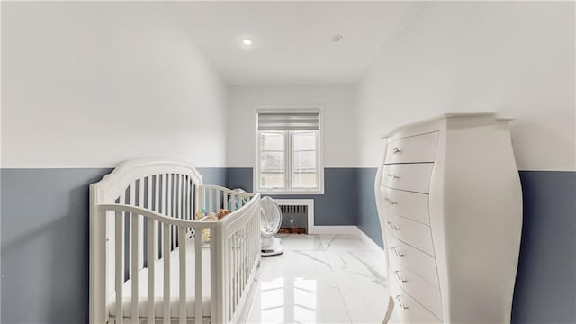 bedroom with radiator heating unit and a nursery area