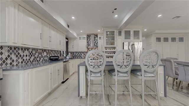 kitchen featuring decorative backsplash, white cabinets, appliances with stainless steel finishes, and a kitchen island