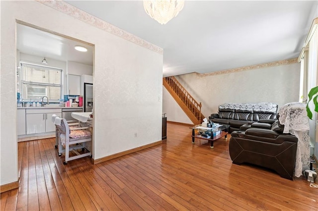 living room featuring wood-type flooring, stairs, and baseboards