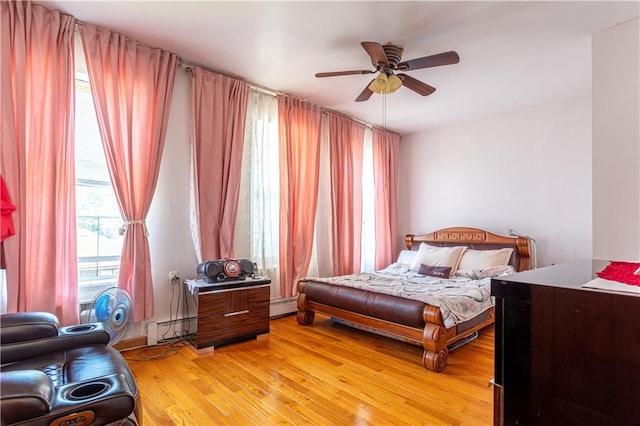 bedroom with a baseboard heating unit, ceiling fan, light wood-type flooring, and a baseboard radiator