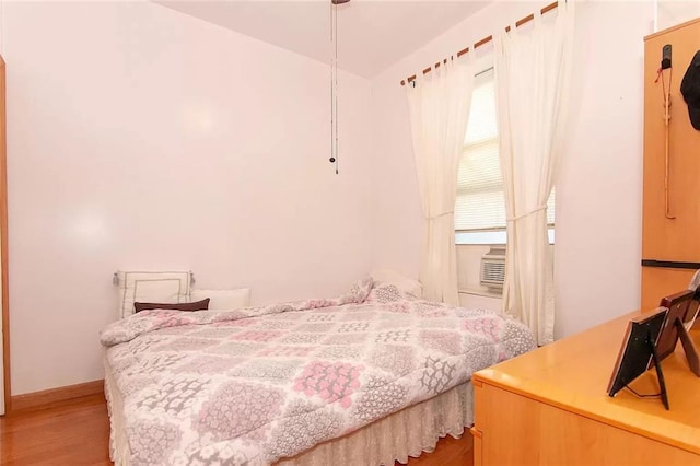 bedroom featuring cooling unit and light wood finished floors