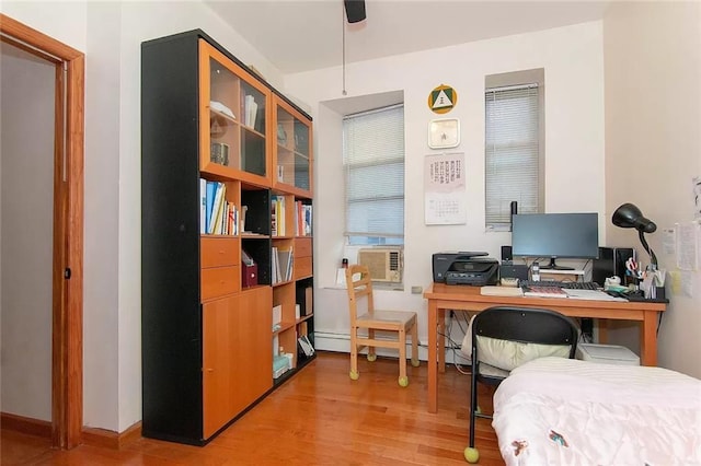 office area featuring cooling unit, baseboard heating, and wood finished floors