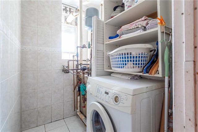 washroom with washer / dryer, tile patterned flooring, laundry area, and tile walls