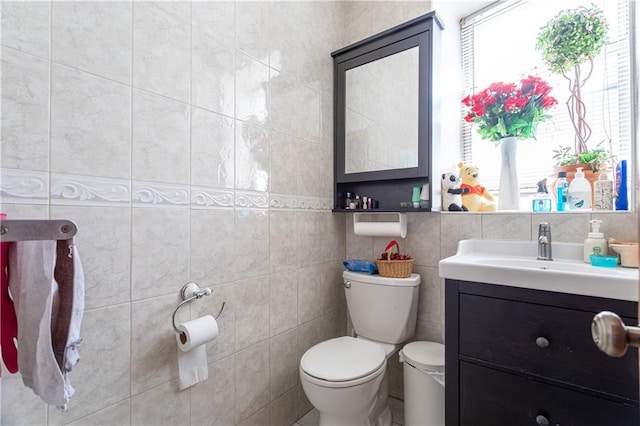 bathroom with tile walls, vanity, and toilet