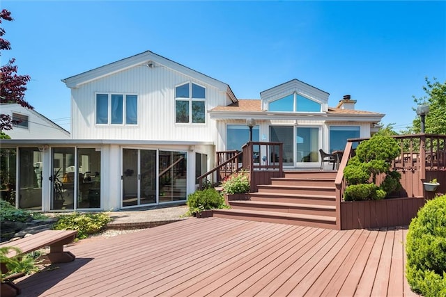 back of house with a wooden deck and a sunroom