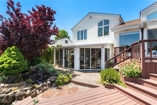 rear view of house with a deck and a sunroom