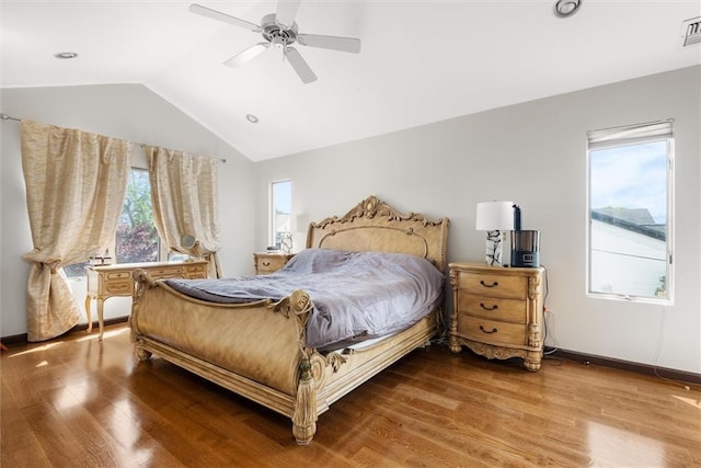 bedroom featuring hardwood / wood-style flooring, lofted ceiling, and multiple windows