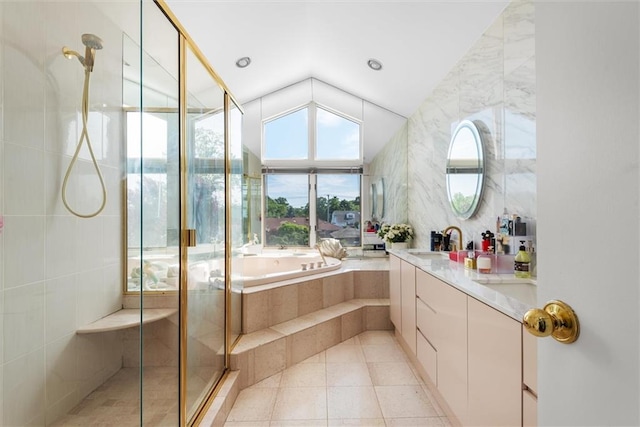 bathroom with tile walls, vanity, plus walk in shower, vaulted ceiling, and tile patterned floors