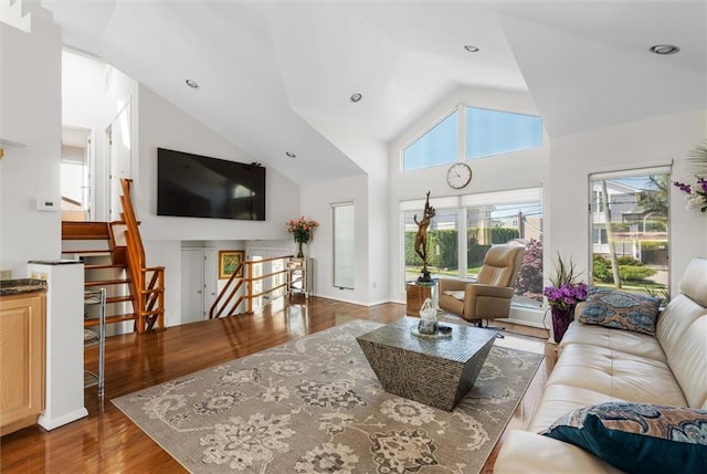 living room with high vaulted ceiling and hardwood / wood-style floors