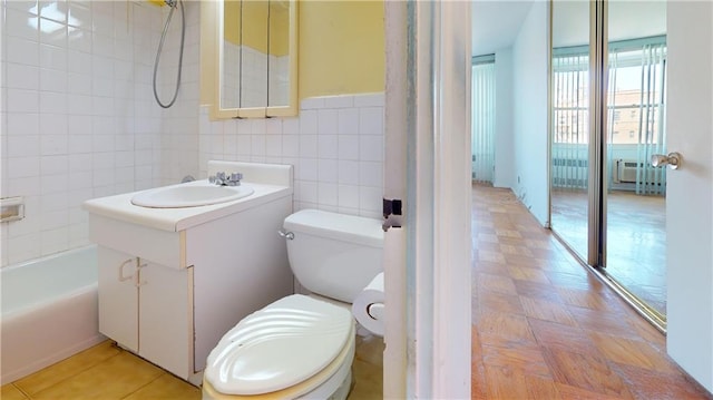 full bath with toilet, vanity, and tile walls