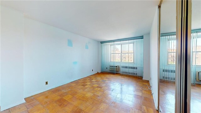 empty room with radiator and light parquet floors