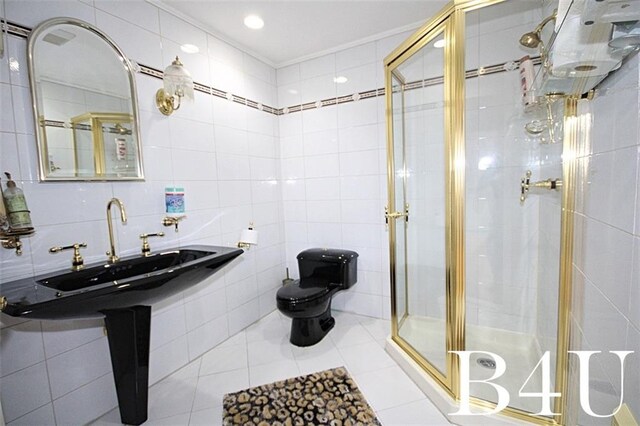 bathroom featuring decorative backsplash, tile walls, tile patterned flooring, an enclosed shower, and toilet