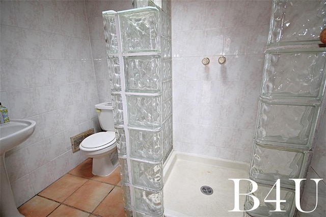 full bath with visible vents, toilet, tile walls, tile patterned flooring, and tiled shower