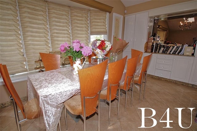 dining area featuring light tile patterned floors, a chandelier, and lofted ceiling