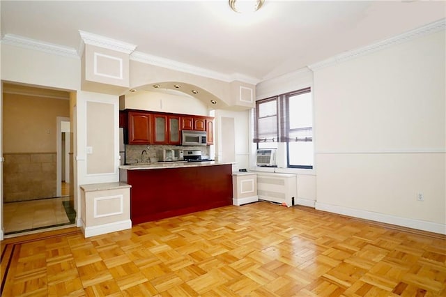 kitchen featuring ornamental molding, decorative backsplash, light countertops, appliances with stainless steel finishes, and reddish brown cabinets