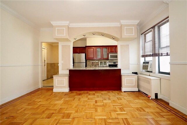 kitchen with freestanding refrigerator, a peninsula, light countertops, decorative backsplash, and white microwave