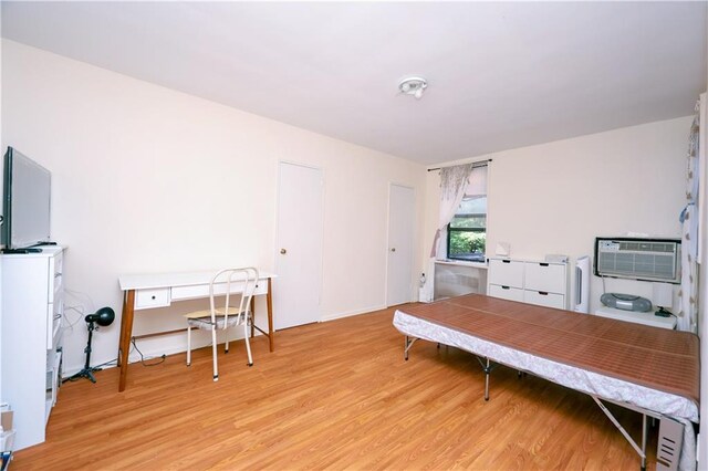 office featuring light hardwood / wood-style floors and an AC wall unit